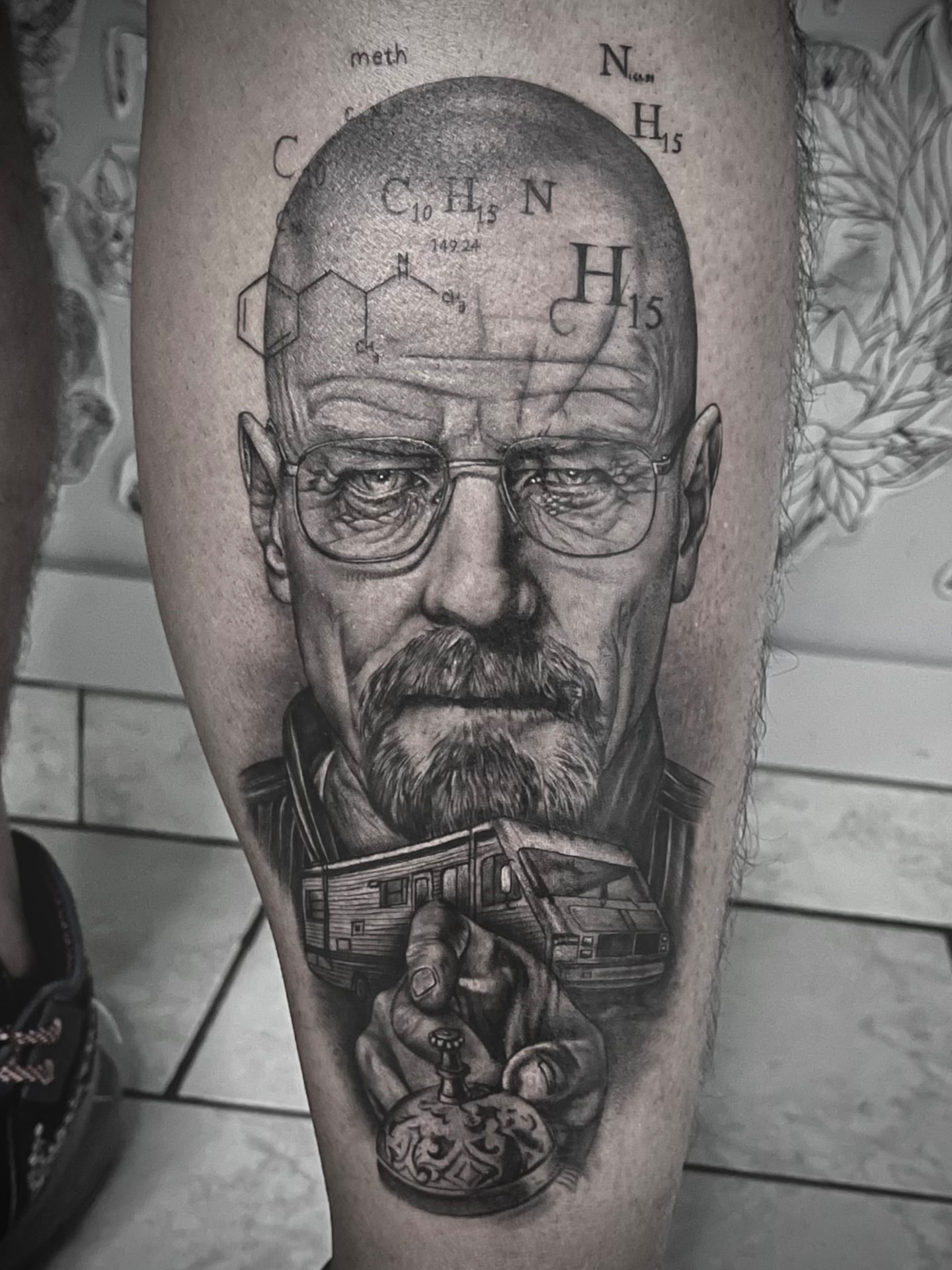 Tatuaggio realistico su polpaccio con ritratto, camper e formule chimiche
