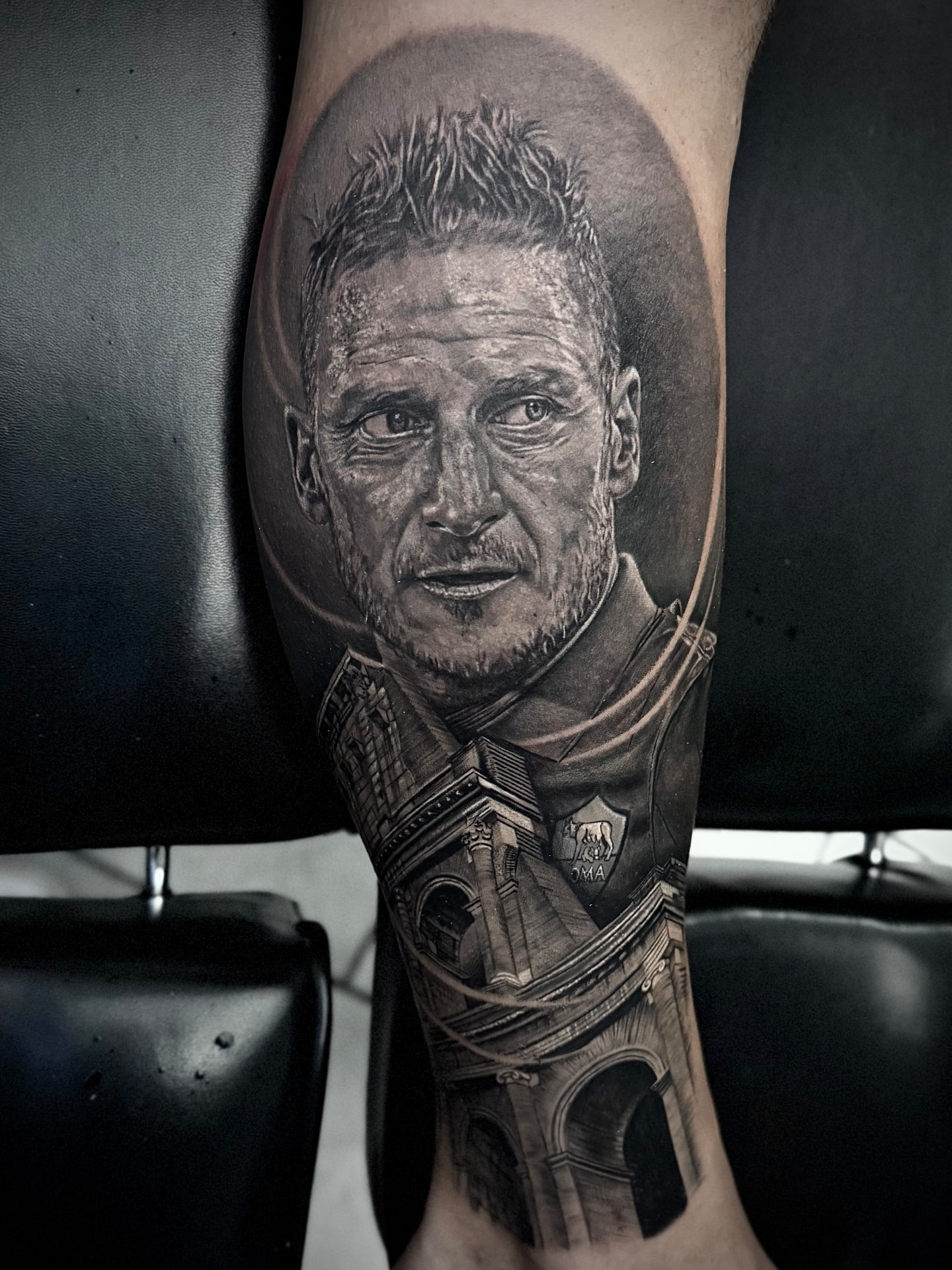 Tatuaggio realistico su polpaccio con ritratto e architettura romana